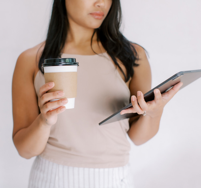 woman holding coffee and ipad